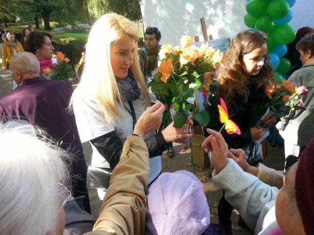Wolontariusze Stowarzyszenia "Mali Braci Ubogich" rozdają seniorom kwiaty    